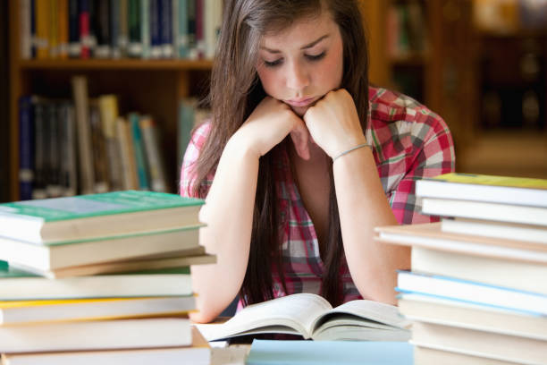 Studious woman surrounded by books in a library