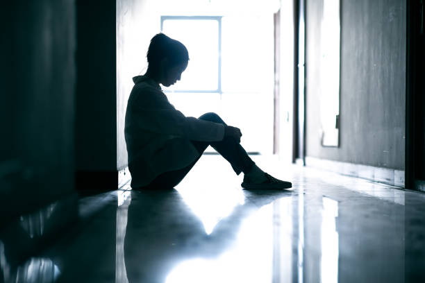 Depressed teenage girls sitting on corridor ground