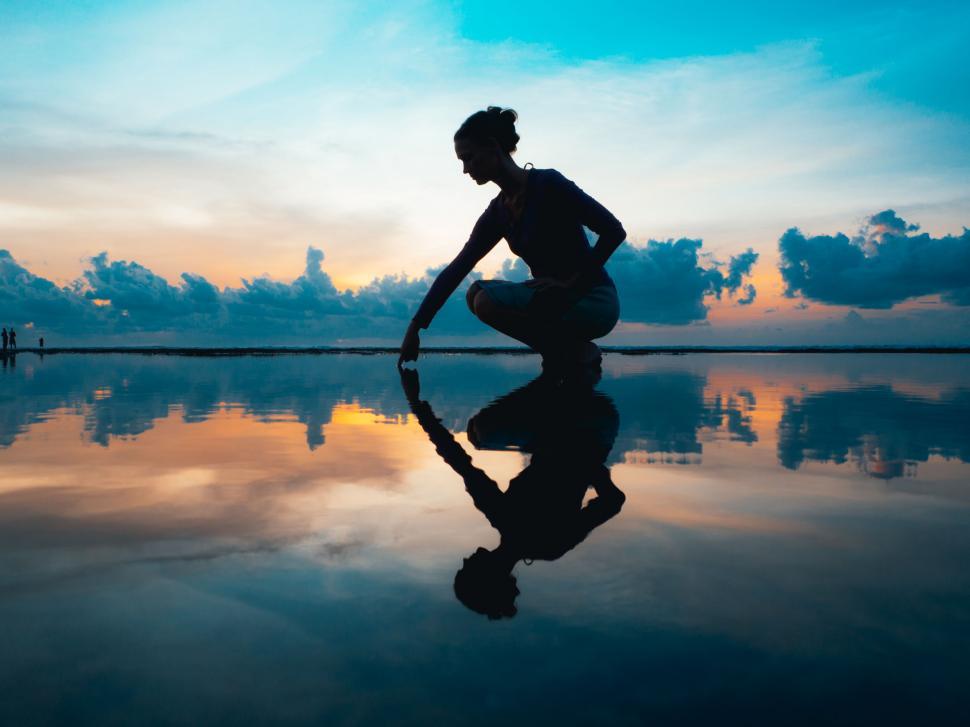 Testimonials and Client Reviews 6 a woman kneeling on a beach
