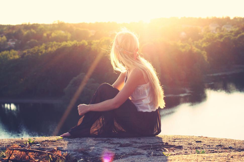 Testimonials and Client Reviews 5 blonde woman on a hilltop overlooking a serene river during sunset